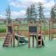 Mini Play II playhouse with slide on green playground surface, wooden playground equipment for child