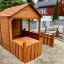 Wooden Garden Playhouse w/ Fencing in a backyard setting.