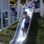 Children playing on the Hill Slide h120 in a park.