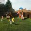 Seal rocking toy on a playground with grass surface and other play structures.