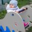 Child playing on Whale rocking spring rider in playground.