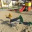 Double Pony rocking playground equipment in a sandy area