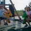 Children playing on a Double Pony rocking seesaw at a playground.
