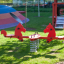 Double Pony rocking in a colorful playground with grass and play structures in the background