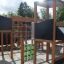 Playground structure with Tic Tac Toe game station and climbing equipment.