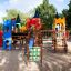 Colorful Tic Tac Toe playground structure with slide and climbing elements in a park setting.