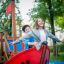 Children playing on the Small Ship sandbox play structure in a park.