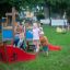 Children playing on a Small Ship sandbox in a park.