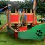 Small Ship sandbox on grass with colorful design and play structures