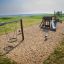 Bike Rocking on playground with slide and swing overlooking a grassy field