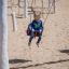 Child swinging on a Nature Double Swing at a playground.