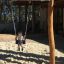 Child enjoying the Nature Double Swing in a playground.