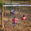 Children playing on Nature Double Swing in a park during autumn.