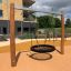 Single Swing playground equipment with a circular net seat in a modern outdoor play area