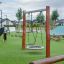 Single Swing on a modern playground with green grass.
