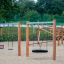 Single Swing - wooden playground structure with various swings on a sandy surface