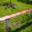 Red Balance playground seesaw with steel springs in a green park.