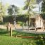Children playing on Tambora Eco wooden playground structure in a park.