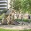 Children playing on a Tambora Eco wooden playground equipment in a park.