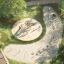 Alstad Eco wooden playground set in a green park with children playing.