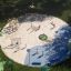 Outdoor sandbox playground with climbing structures, swings, and children playing, Ural Eco.