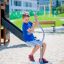 Boy playing on Spinner II at playground.