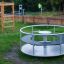 Modern Merry-Go-Round playground equipment in a park.