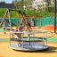 Child playing on the Merry-Go-Round at a vibrant playground.