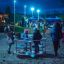 Children playing on the Merry-Go-Round playground equipment at night.