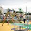 Children playing on the Merry-Go-Round in a colorful playground.