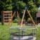 Playground Merry-Go-Round with climbing frame and swing set in the background.