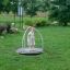 A small child standing on the Bee playground equipment in a park.