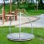A round playground spinner called Bee with metal bars and a textured surface.