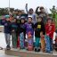 Children posing with skateboards at a skate park.
