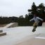 Child using Bank ramp at an outdoor skate park