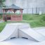 Skate ramp in a park next to a wooden gazebo.