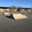 Combination 16 skate park ramps in an outdoor area with buildings in the background.