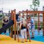 Climbing Kiosk Nature wooden playground structure with slide and climbing net, children playing