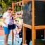 Children playing on the Climbing Kiosk Nature playground equipment.