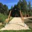 Medium Cableway playground equipment in a park with wooden and metal frame on a sandy path.
