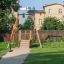Medium Cableway playground equipment in a park with grass and trees in the background.