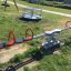 Double Seesaw at a playground with red handles and black seats