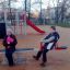 Children playing on Double Seesaw in a playground.