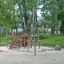Powerclimber climbing net in a playground surrounded by trees.