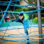 Child climbing on Powerclimber climbing net in playground.