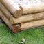 Wooden Sandbox frame corner on grassy field.