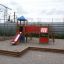 Outdoor playground with a red slide and a tower.