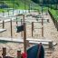 Small Ship Nature playground apparatus on a sandy surface in a park setting.