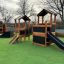 Wooden playground structure with slides and climbing areas from Ship Nature Sandbox.