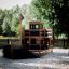 Wooden playground structure shaped like a ship in a sandbox.